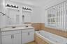 Dual vanity with undermount sinks, white cabinetry, and a light-toned countertop