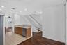 Kitchen with wood-finish cabinetry, stainless steel dishwasher, and light-toned countertops