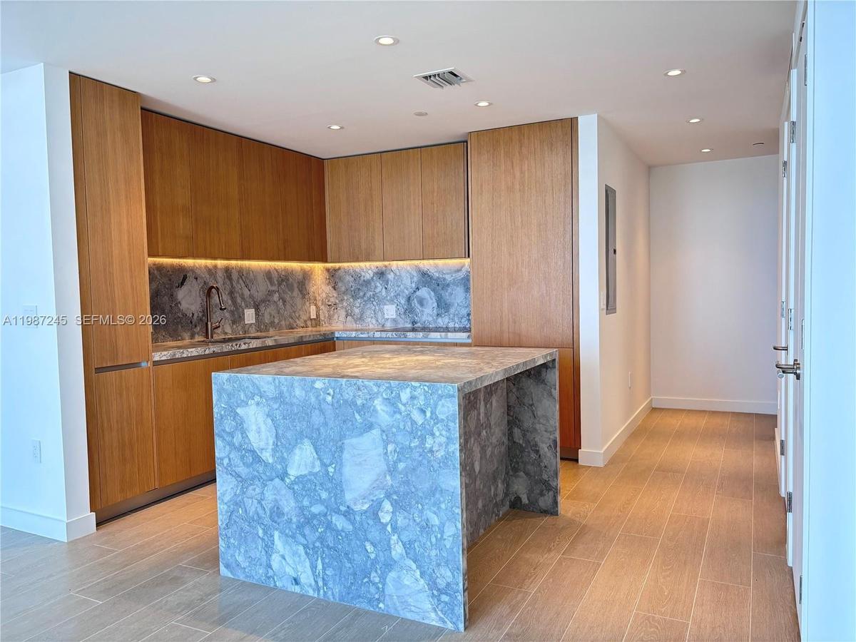 Kitchen with custom island in matching ItalKraft cabinetry and quartzite waterfall