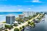 Coastal real estate featuring oceanfront buildings, waterfront properties with boat docks, and a wide sandy beach