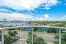 Expansive water and city views from a private balcony with a glass railing and aluminum frame