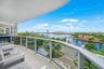 Expansive balcony featuring a glass railing, concrete flooring, and a curved ceiling