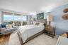 Floor-to-ceiling sliding glass doors, hardwood flooring, crown molding, and wall sconces