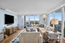 Wood-finish flooring, crown molding, floor-to-ceiling windows, and a built-in wall-mounted television