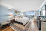 Wood-finish flooring, crown molding, and a sliding glass door leading to a balcony