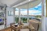 Floor-to-ceiling glass sliding doors, built-in shelving, crown molding, recessed lighting, and wood-finish flooring