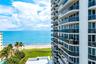 Oceanfront high-rise building with extensive balconies, glass railings, and a beachside location