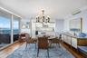 Hardwood-finish flooring, sliding glass doors to a balcony, contemporary chandelier, and a built-in buffet