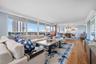 Open-concept living area featuring wood-finish flooring, a full wall of windows, and recessed lighting
