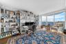 Built-in shelving, wood-finish flooring, full-height windows, and waterfront scenery