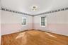 Bedroom four is at the end of the hall, to the back of the house and has windows on two sides of the space.