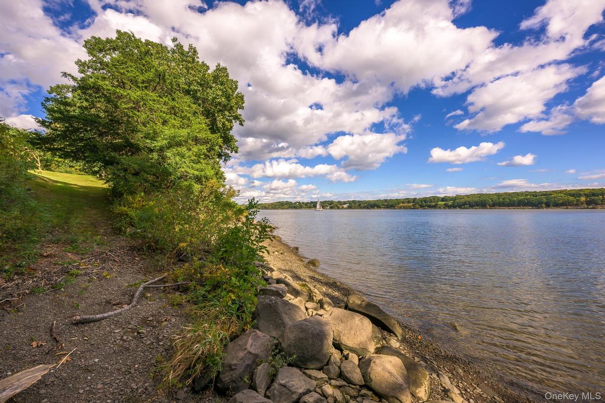 Expansive waterfront property featuring a natural shoreline, mature trees, and a clear water body