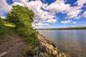 Expansive waterfront property featuring a natural shoreline, mature trees, and a clear water body