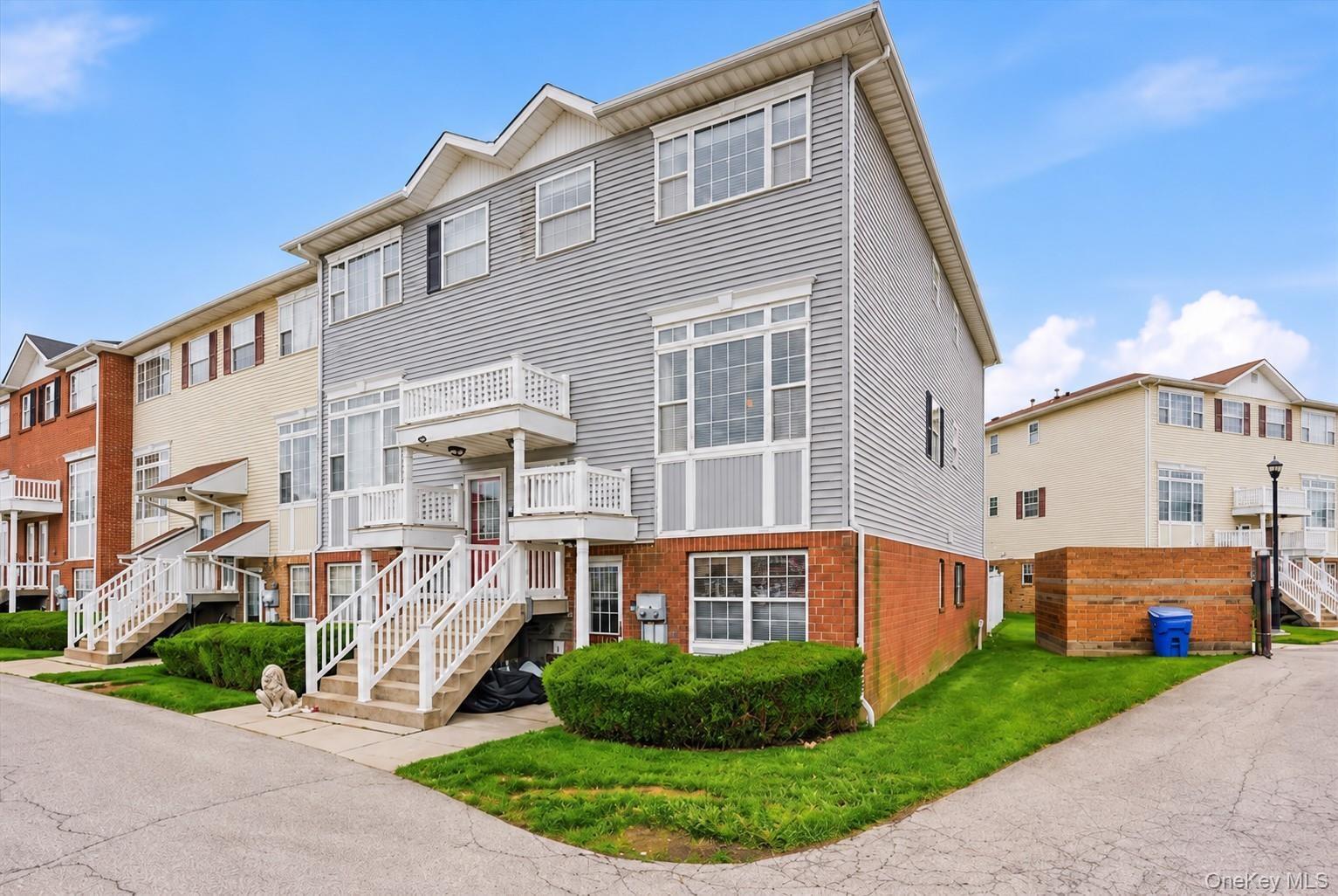 Multi-level townhouse with brick and siding exterior, and dedicated entryways