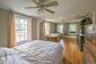Hardwood flooring throughout, multiple windows, ceiling fans, and paneling
