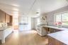 Kitchen featuring wood-finish flooring, white cabinetry, a freestanding range, and a built-in sink