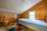 Sloped ceiling, wood paneling, white window frame, and checkered flooring