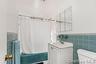 main unit Bathroom  tile walls, shower / tub combo, vanity, and wainscoting