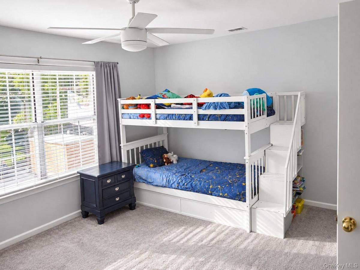 Carpeted room with a ceiling fan