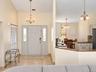Vaulted entry with decorative chandelier, tile flooring, and double-pane sidelight windows