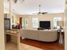Hardwood-finish flooring, recessed lighting, ceiling fan, sliding glass door, and granite-finish countertop on a built-in desk