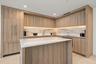 Kitchen featuring wood-finish cabinetry with integrated appliances, stone-patterned backsplash, quartz-topped center island, and recessed ceiling ligh