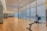 Fitness facility featuring wood-finish flooring, floor-to-ceiling windows, full-wall mirrors, and recessed ceiling lighting