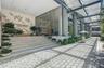 Building exterior featuring a glass curtain wall, expansive paver walkway, overhead steel-frame canopy, and integrated wide-tread stairs with decorati