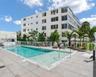 Outdoor swimming pool with a sun shelf, stone-tiled pool deck, and perimeter glass railing