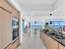 Gourmet kitchen featuring wood-finish cabinetry, stainless steel appliances, and sleek dark stone countertops with an undermount sink.