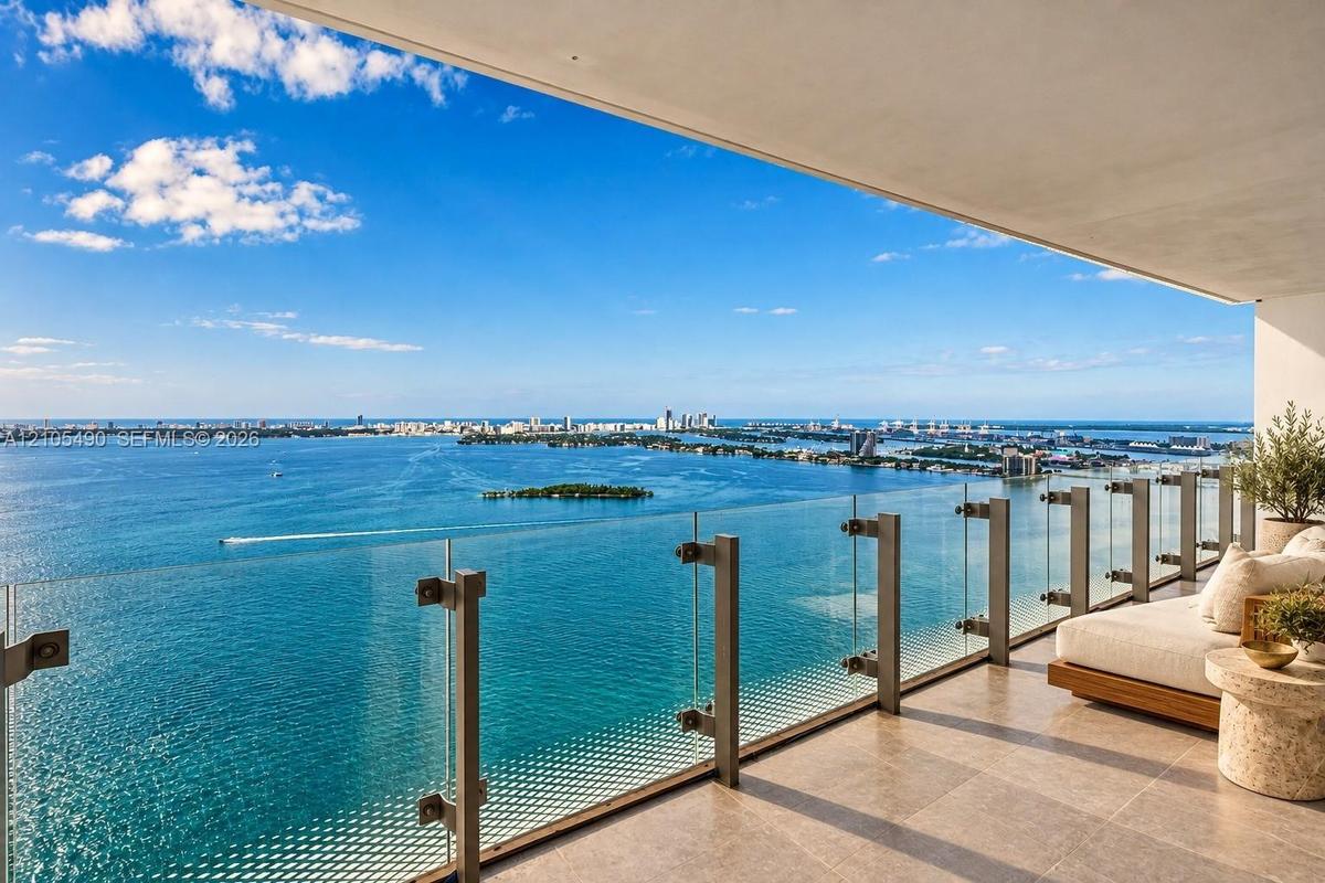 Private balcony featuring large-format tile flooring and a frameless glass railing system with metal hardware