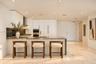 Modern kitchen featuring flat-panel cabinetry, stone countertops, integrated stainless steel appliances, recessed lighting, and large-format tile floo