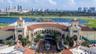 Mediterranean-inspired architecture featuring dual towers, arched entryways, a central courtyard fountain, and terracotta roofing