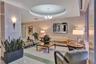 Lobby featuring a circular tray ceiling, polished stone flooring, recessed lighting, and wall-mounted light fixtures