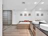 Luxurious spa-inspired bathroom featuring dual vessel sinks, an expansive vanity with built-in storage, a full-width mirror, a soaking tub, and a sepa