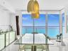Elegant dining area featuring floor-to-ceiling glass doors and windows, large-format tile flooring, contemporary pendant lighting, and a glass-top din
