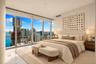 Floor-to-ceiling windows, neutral tile flooring, and urban water scenery