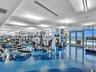 Expansive fitness center featuring a blue and dark blue patterned floor, floor-to-ceiling windows, and abundant natural light