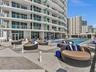 Experience oceanfront resort-style living at Apogee Beach, featuring an inviting swimming pool, expansive pool deck, sleek glass railings, and direct 