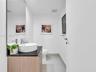 Floating wood-finish vanity with a dark countertop and vessel sink