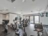 Fitness facility featuring rubberized flooring, mirrored walls, recessed lighting, and expansive windows