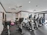 Fitness space featuring rubberized flooring, recessed lighting, multiple ceiling fans, and dark-toned wood trim