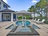 Outdoor living area featuring a rectangular swimming pool with a built-in spa, a tanning ledge with dual in-pool loungers, large-format tile pool deck