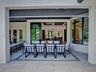 Covered patio featuring large-format stone tile flooring, multi-panel retractable glass doors, recessed ceiling lighting, and expansive windows