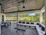 Covered lanai featuring large-format tile flooring, wood-plank ceiling, recessed lighting, ceiling fans, and black metal railings