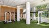Fitness space featuring floor-to-ceiling windows, wood-paneled walls, synthetic turf flooring, recessed ceiling lighting, and structural cylindrical c