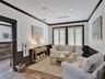 Interior room featuring dark wood wainscoting, crown molding, and window casings