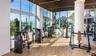 Fitness center featuring floor-to-ceiling windows, wood-finish flooring, linear slat ceiling detail, and integrated lighting