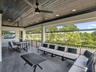 Covered balcony featuring dark-stained wood-plank ceiling, recessed lighting, tile flooring, and metal railing