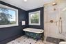 Picture windwow over the decoratively painted. Claw-foot soaking tub.